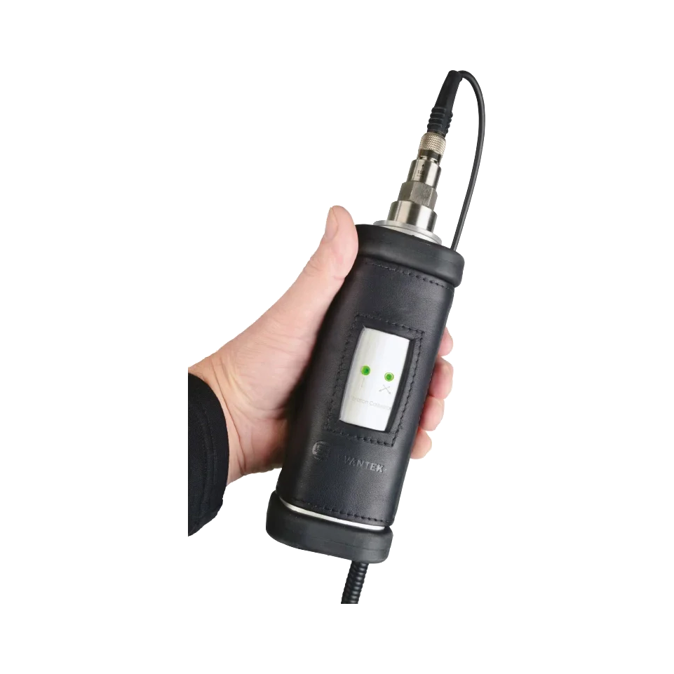 Hand holding a black Svantek SV 110 Vibration Calibrator with a white background